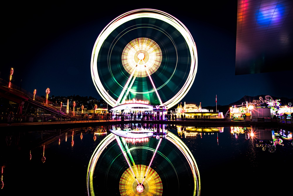 Riesenrad bei Nacht mit Spiegelung im Wasser